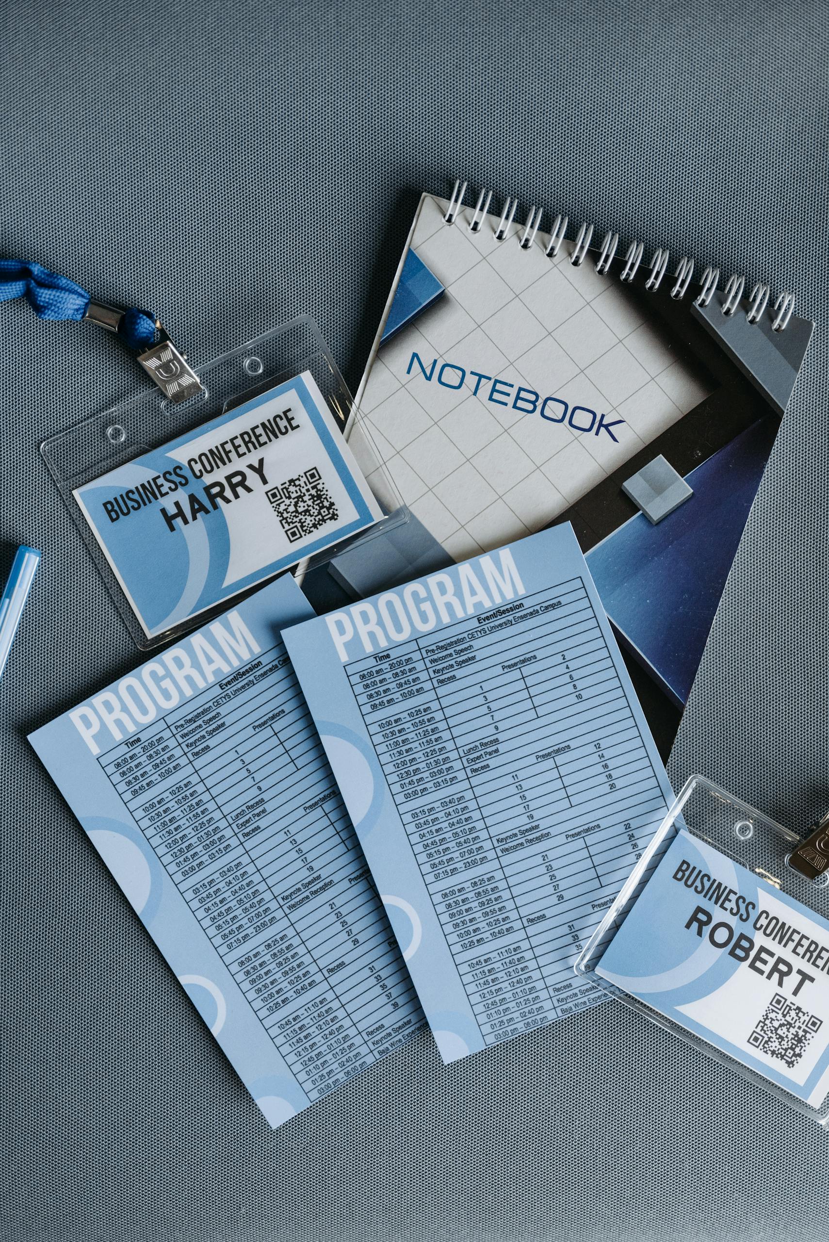 High angle shot of business conference name tags and program sheets on a gray surface.